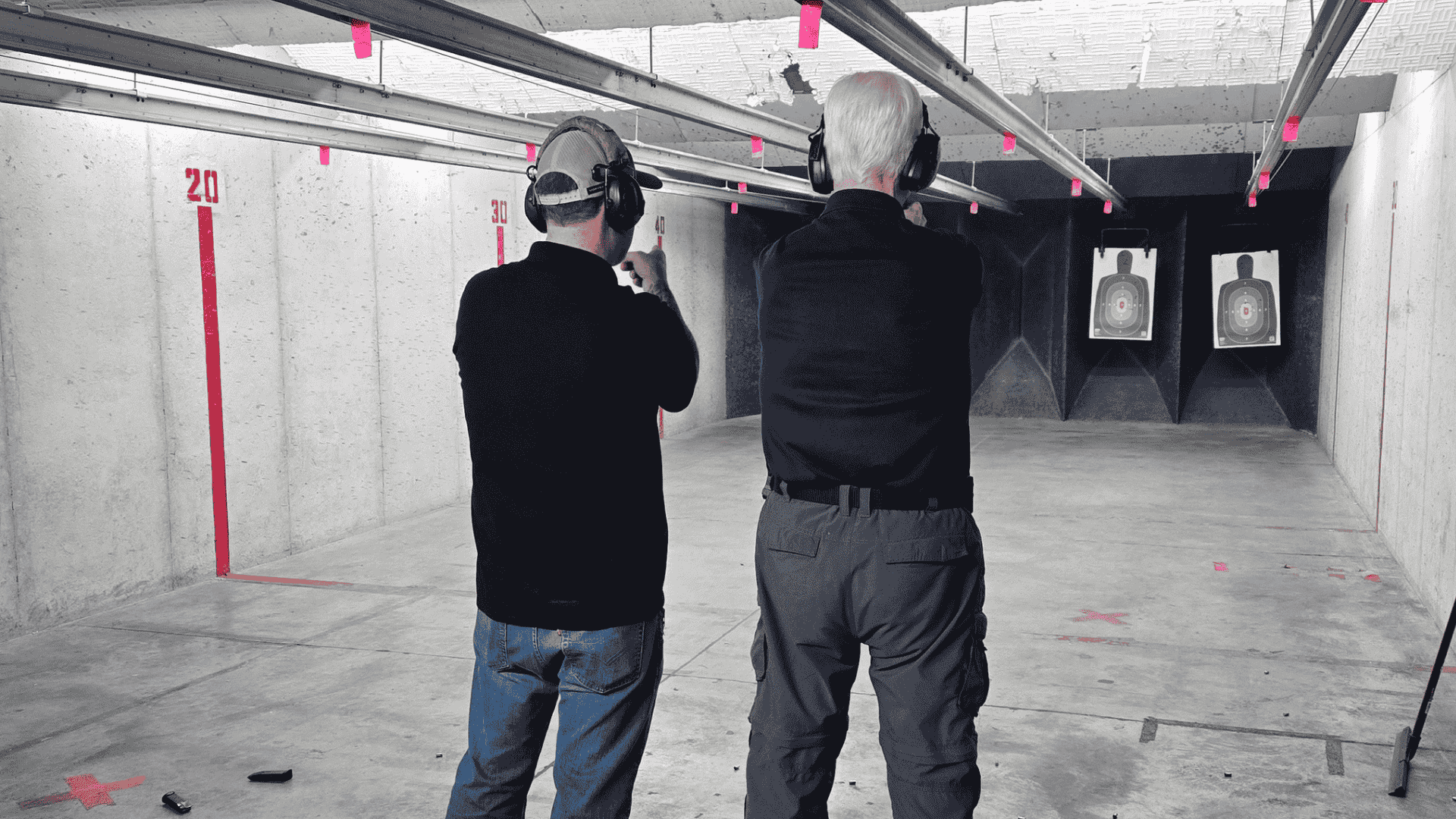 Firearms instructor working with a student at a firing range.