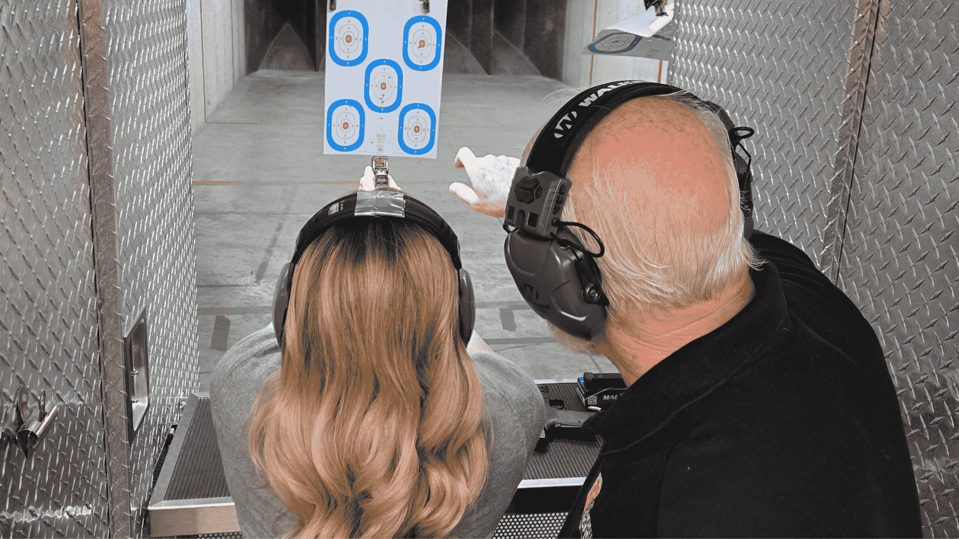 Instructor guiding student at shooting range